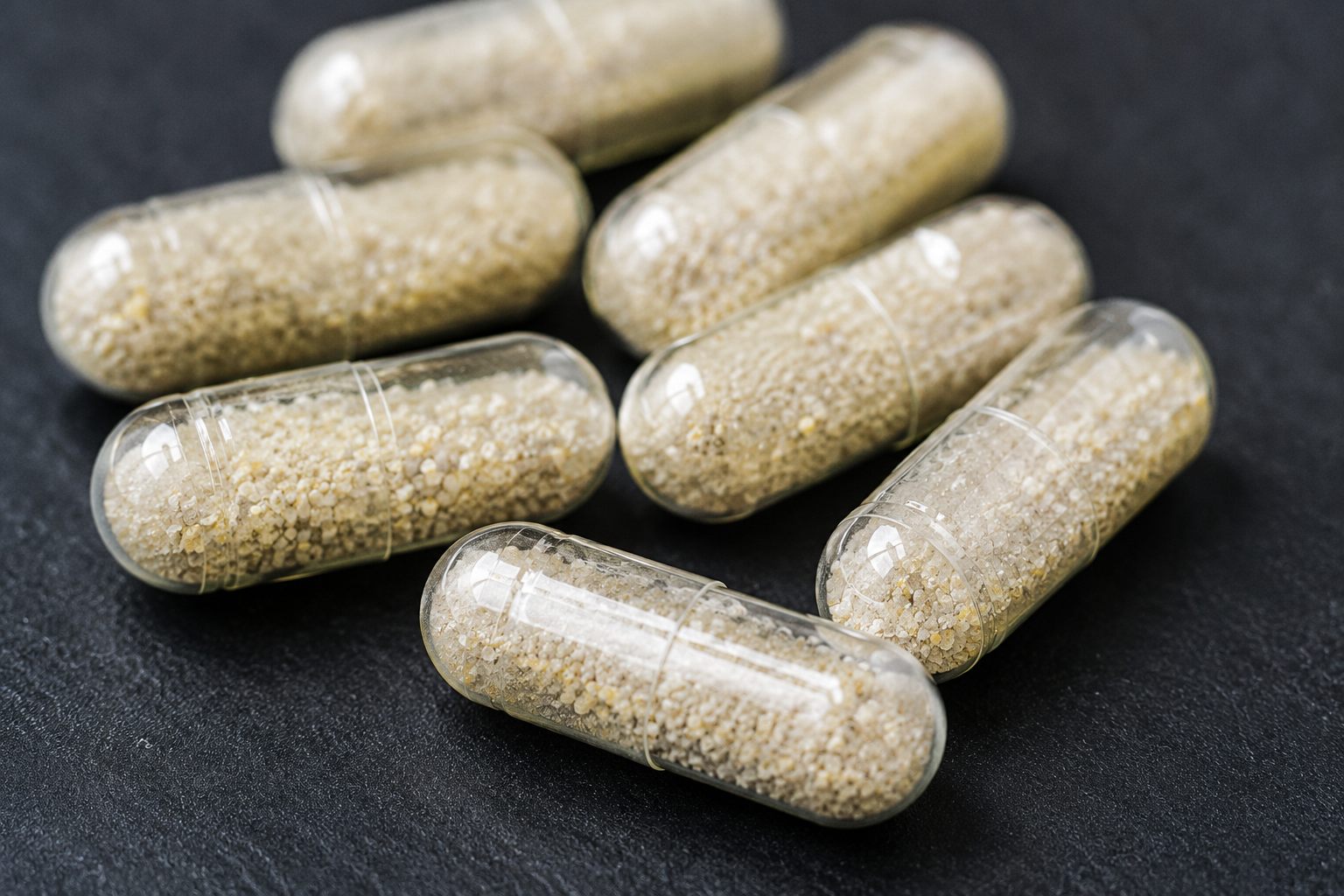 Close-up of delayed-release probiotic capsules containing live powdered cultures.